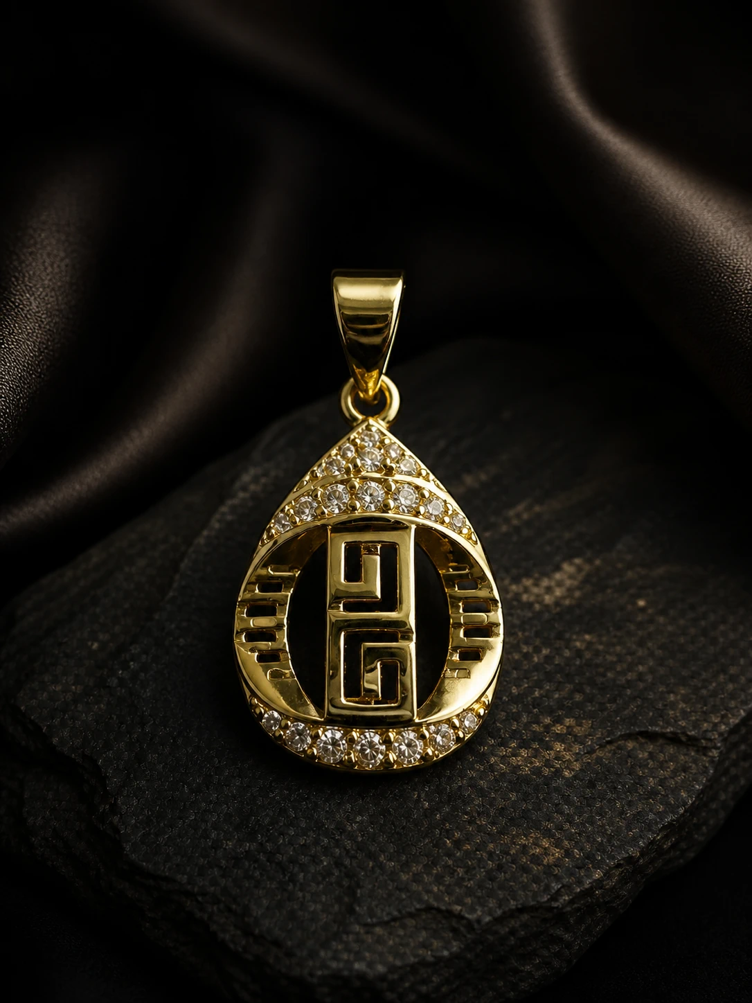 Colgante dorado en forma de gota con greca central y cristales