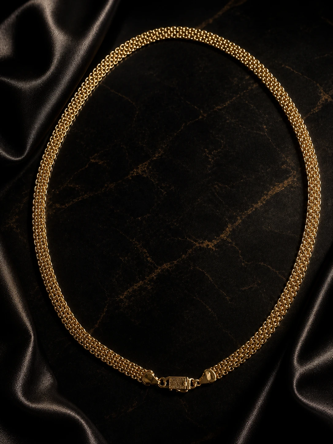 Collar dorado de malla múltiple sobre fondo negro