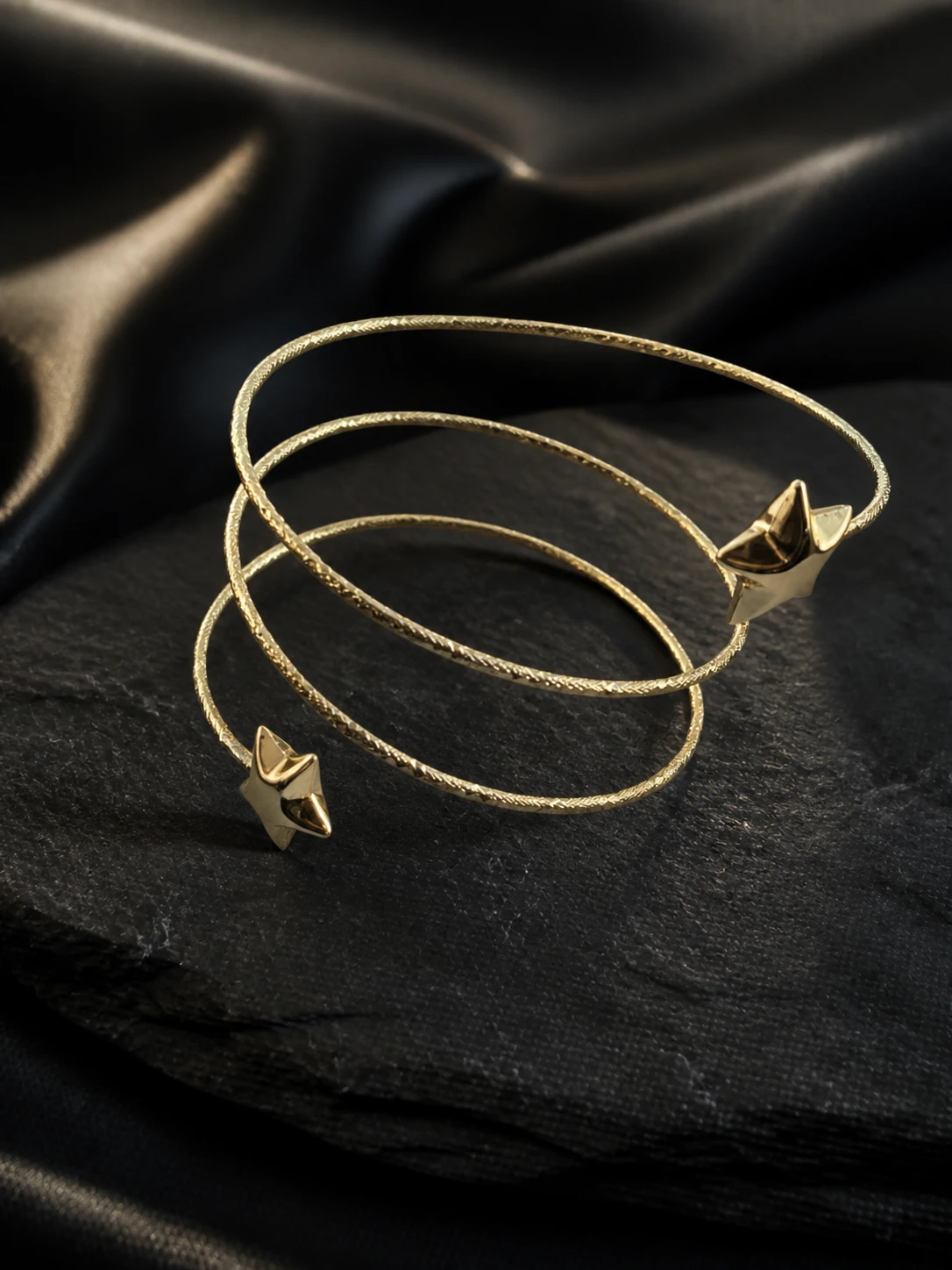 Pulsera espiral dorada de tres vueltas con puntas de estrella