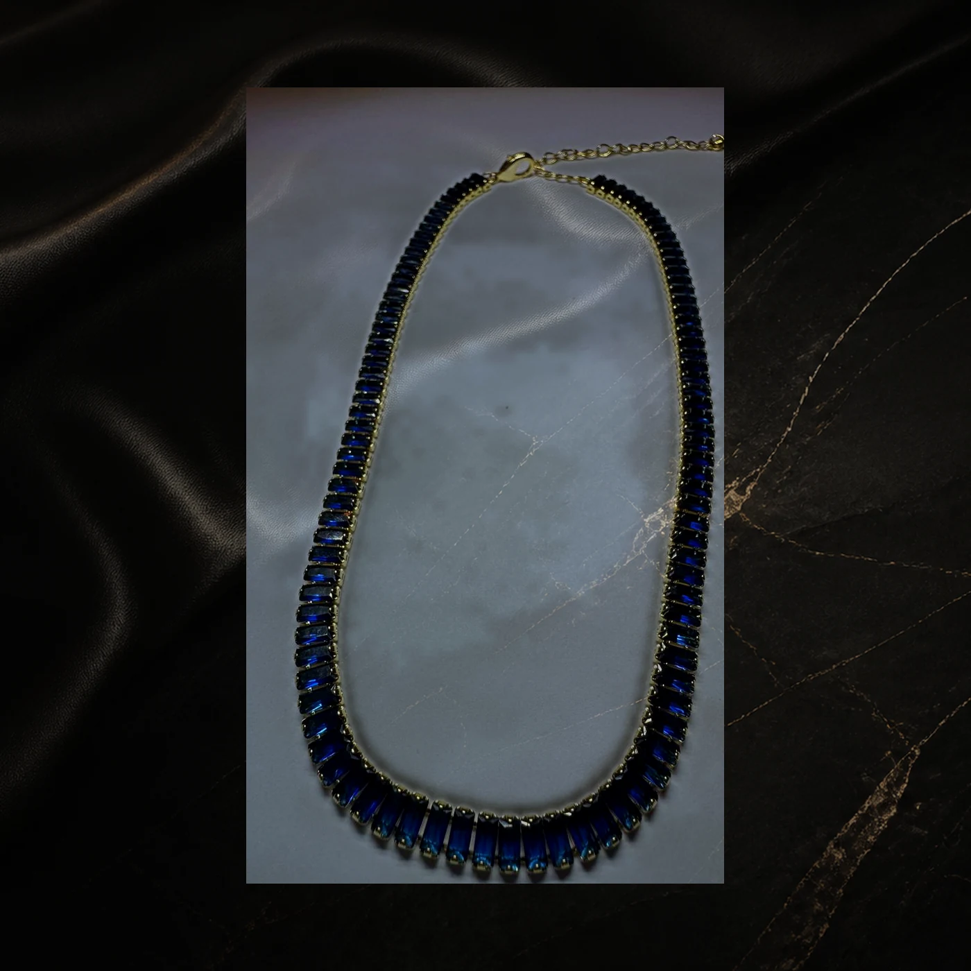 Collar dorado con gemas rectangulares azul profundo