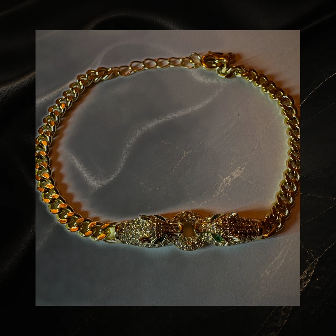 Pulsera dorada con dos cabezas de pantera pavé y ojos verdes